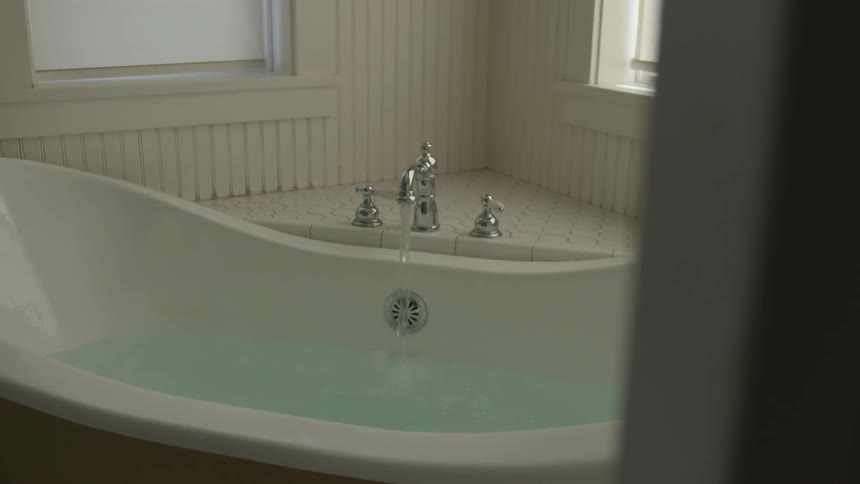 A bathtub that is being filled with water