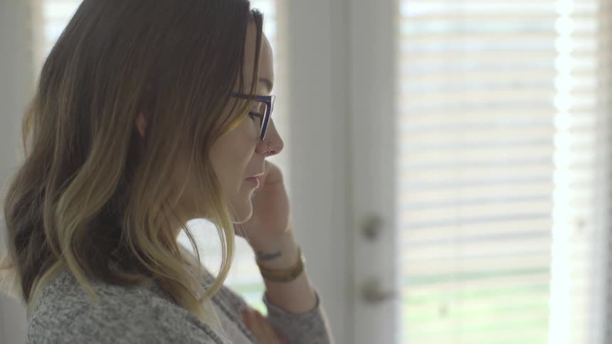 A woman is standing and talking on a cell phone