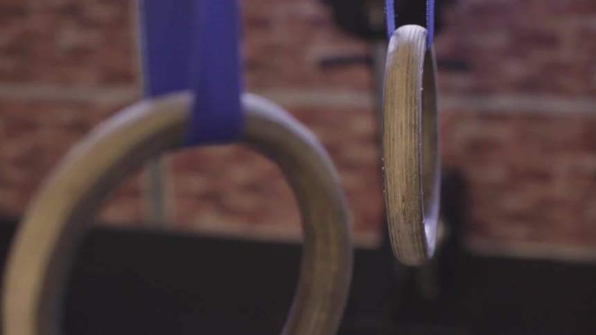 Rings that are hanging and swinging in a gym