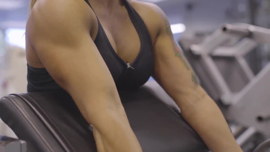 Woman curls a weight lifting bar