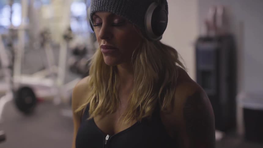 Woman listening to music on headphones at a gym