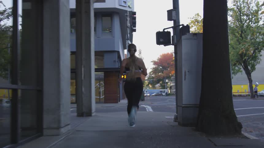 A jogger runs across a crosswalk in a city