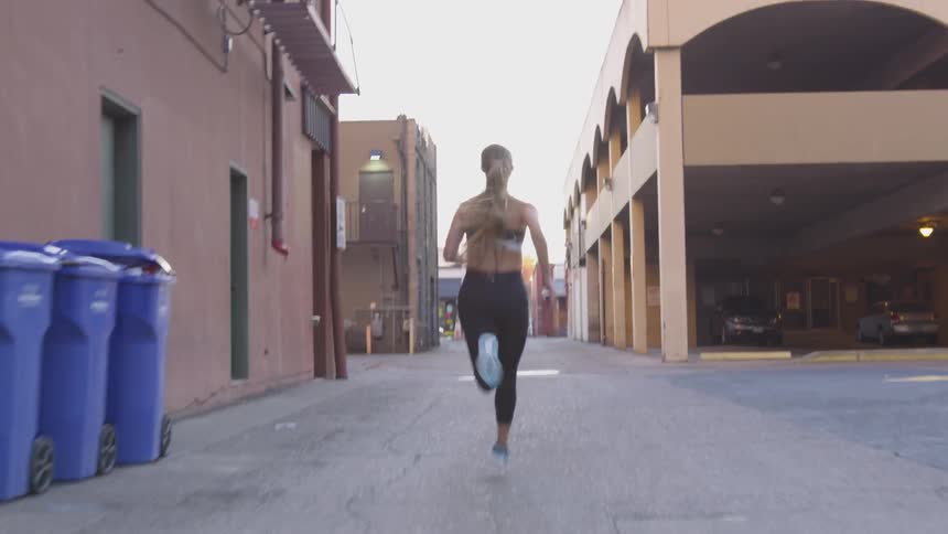 A woman runs through the alley