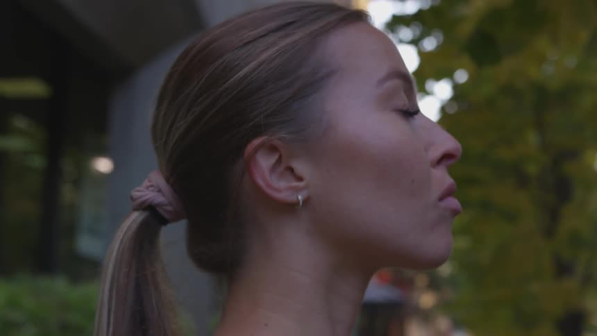 A woman staring at something off screen outside of a building