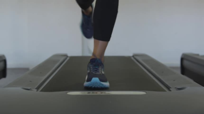 A woman's legs as she runs on a treadmill