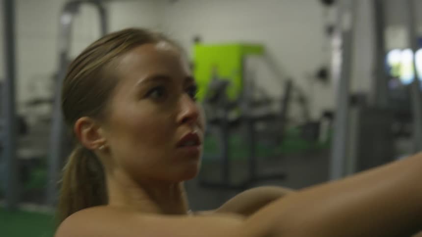 Woman exercising at the gym with stretching cables