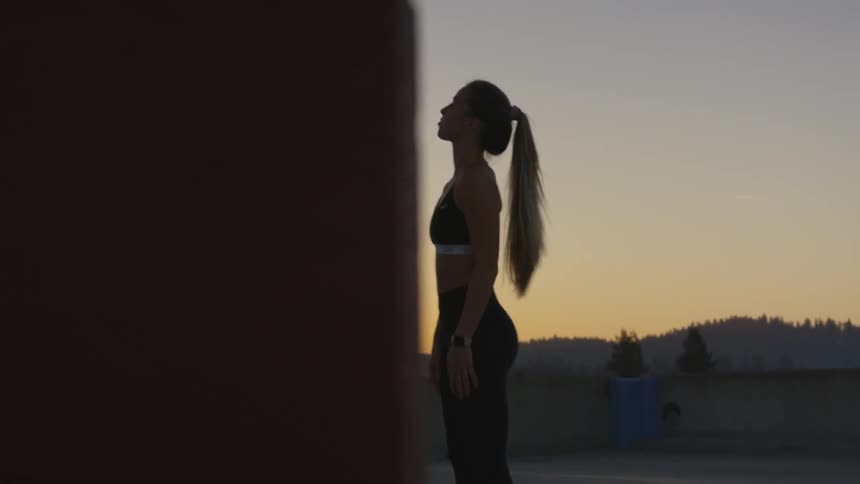 White woman warming up and stretching at a rooftop