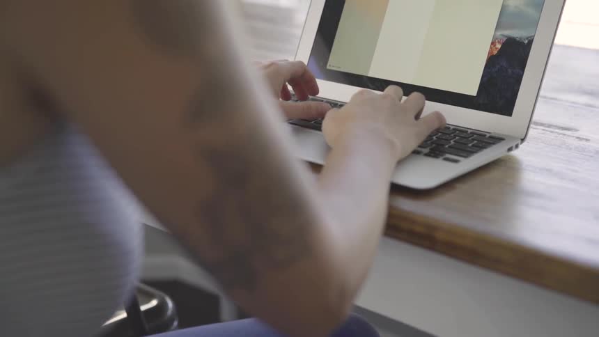 A woman writing on a laptop computer
