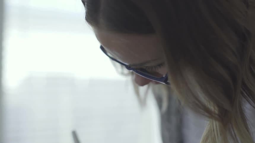 Woman with glasses writing