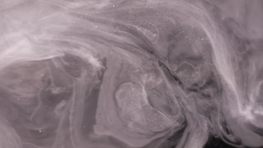 White swirls move around in a dark area
