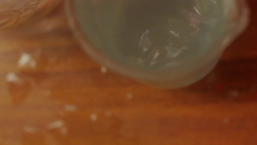 Two glasses filled with liquid are shaking violently on a table