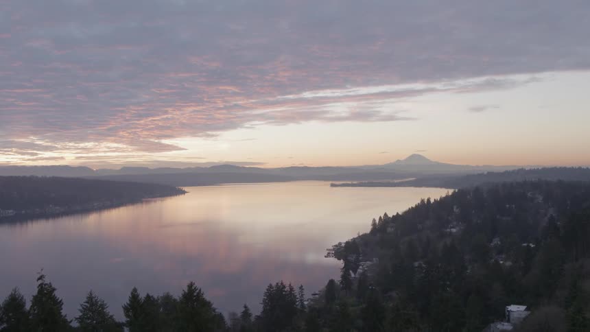 Ascending over a Seattle neighborhood to reveal Lake Washington and Mount Rainier at dawn
