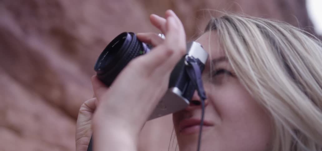 A young woman takes a picture with her camera