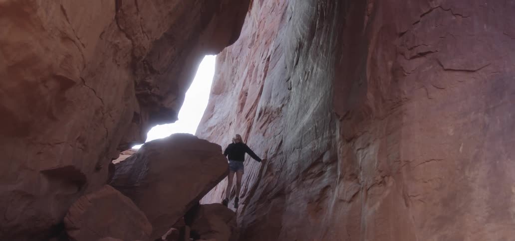 A female photographer climbing rocks for a photo