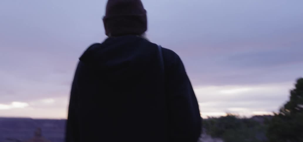 A woman with a hat and a jacket walking outside