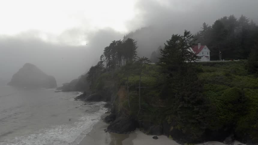 Thick clouds cover a home on a cliff