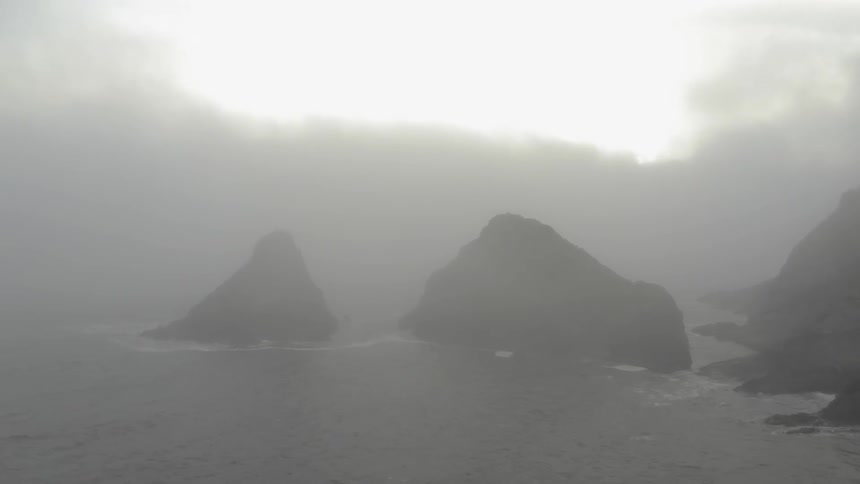 Fog overpowers the rocks near the ocean