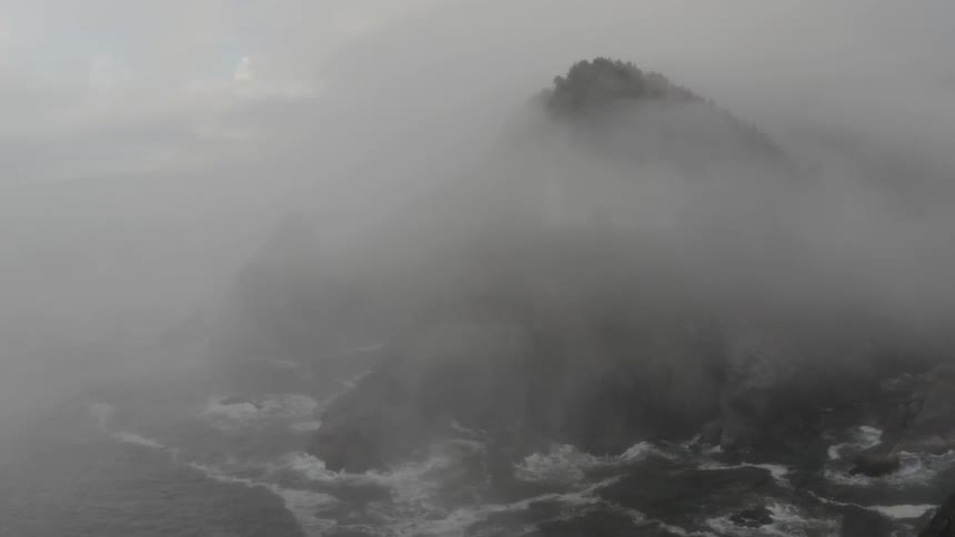 Mist enshrouds a mountain on an island