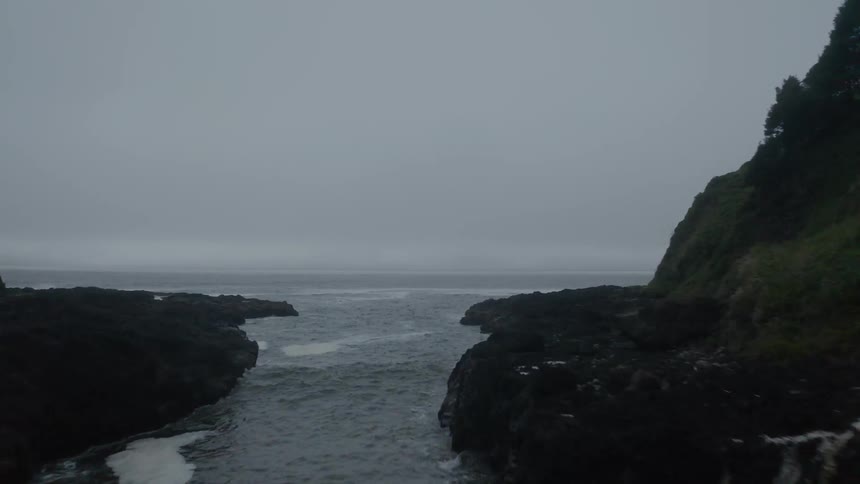 A thin ravine leading to the ocean on a cloudy day