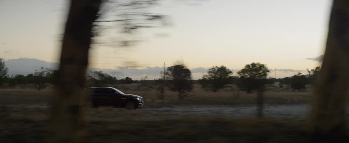 A vehicle traveling on a road near trees
