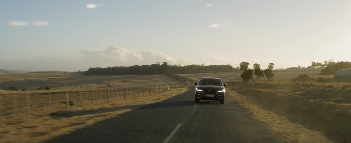 A car drives along a rural road
