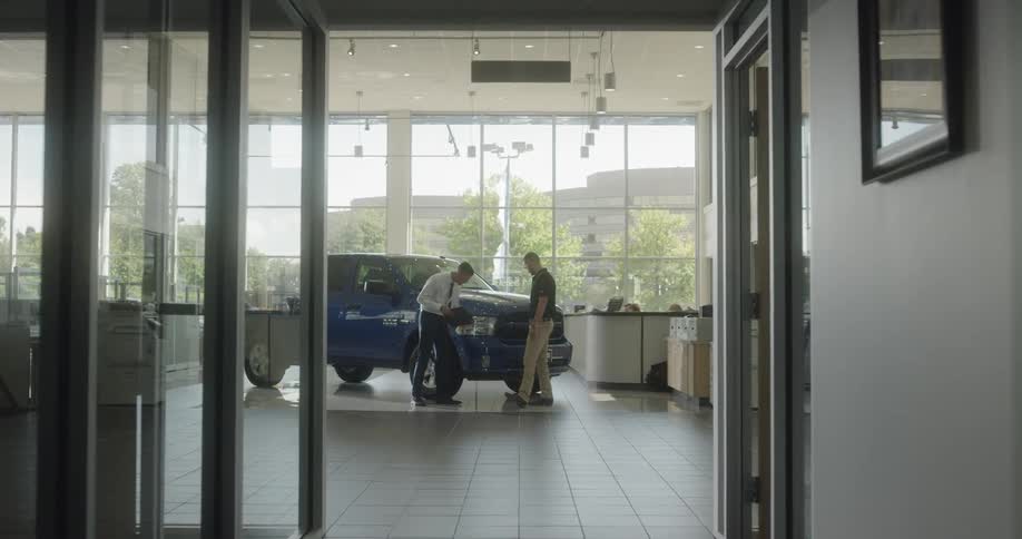 Salesman and customer looking over a new truck at a dealership