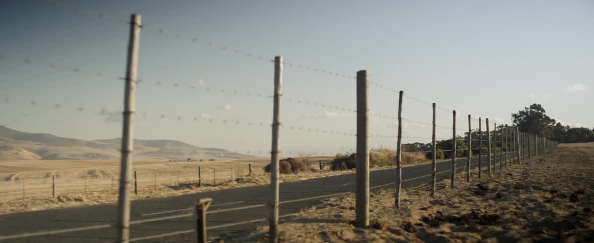 A road that has barbed wire on the side of it