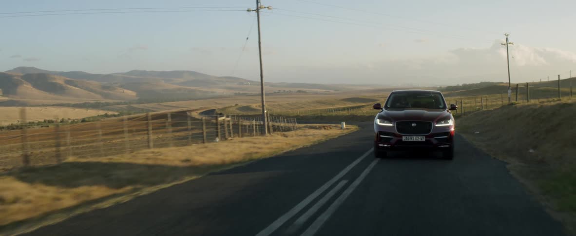 A car driving on a rural road at sunset