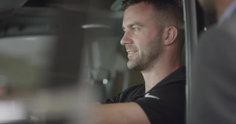 A man sits in the driver's seat of a truck