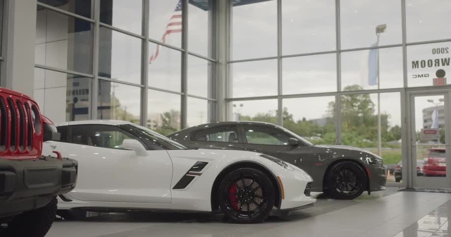Many cars sit on the showroom floor