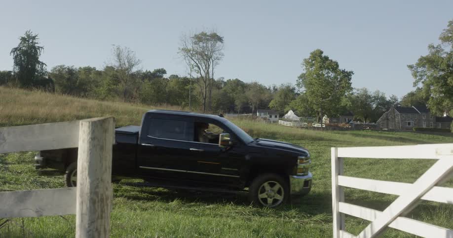 People pull up to open fence gate in pickup truck