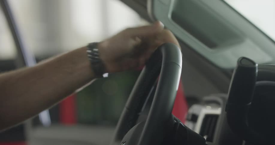 A man gets in the car in the garage