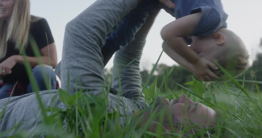 A man woman and young boy play in the grass
