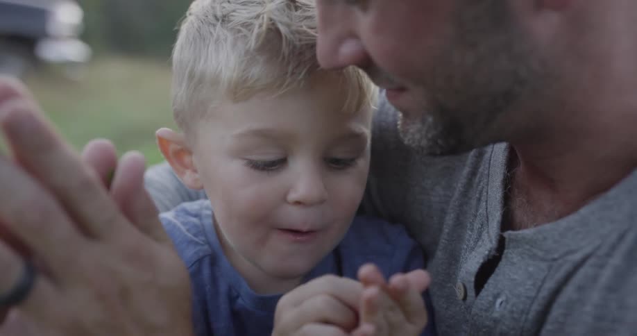 Man holds a young boy on his lap as they play