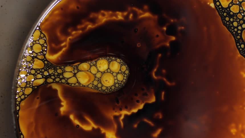 An orange and yellow substance moves in a dish
