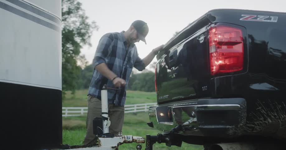 A man loosens a connection for a trailer