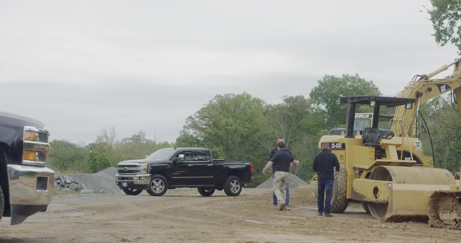 A man greeting two other men on a construction site