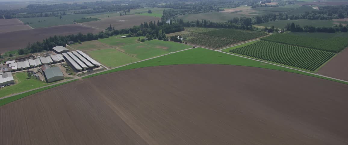 Aerial footage of farms and greenhouses in the countryside