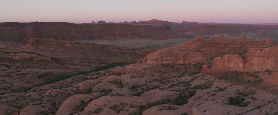 A desert with red plateaus and a river running through it