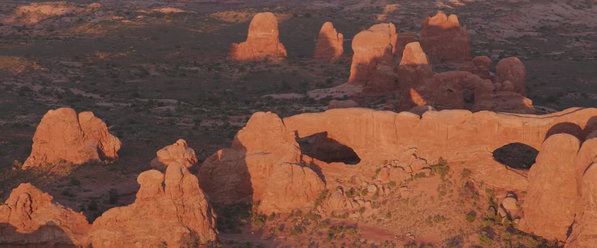 An aerial view of red rock formations in a desert