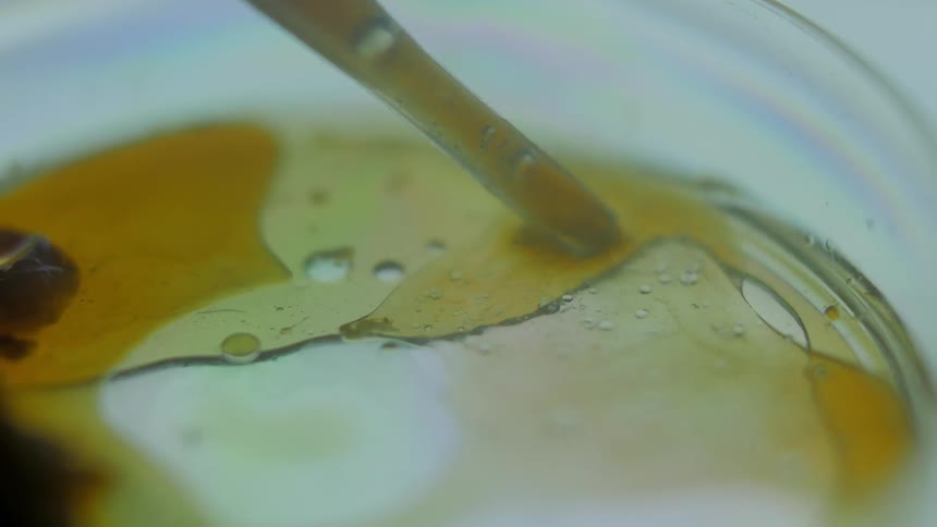A syringe sucks up brown liquid
