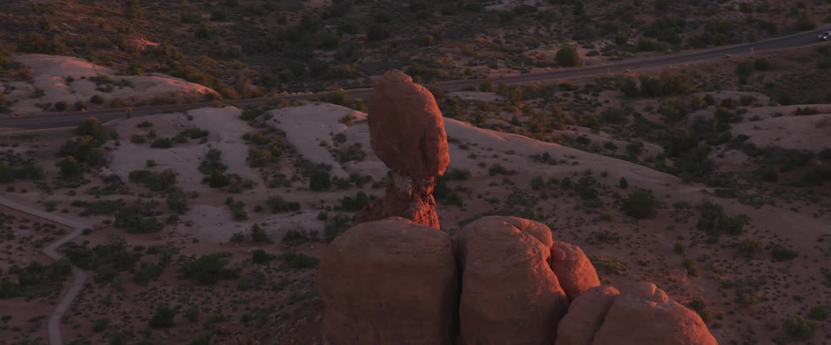 The sun is setting on the rock formations in the desert