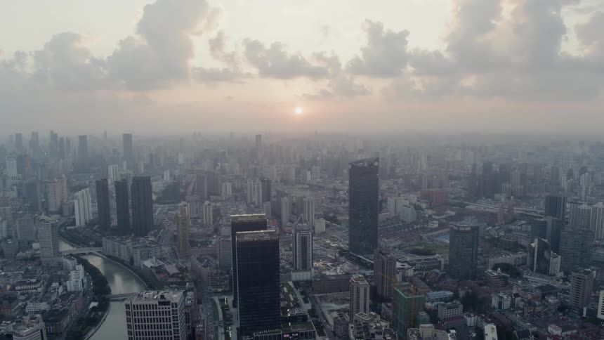 The sun hovers over the vast Shanghai skyline