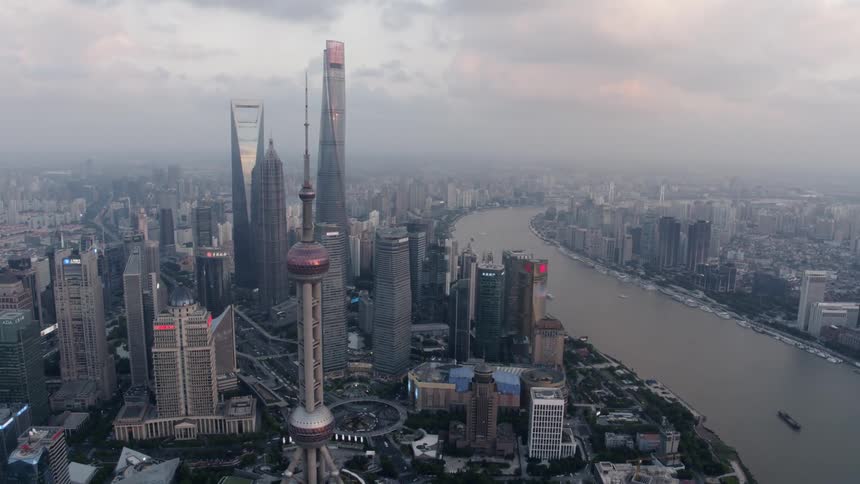 Aerial view of a city skyline next to a river at sunset