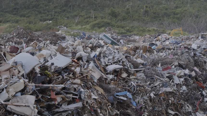 The camera flies over huge mounds of of scrap and junk