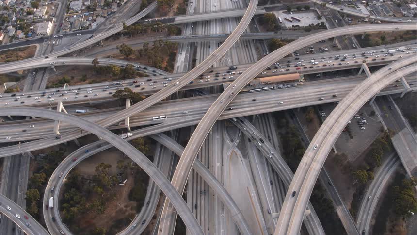 The camera flies above a complex freeway interchange