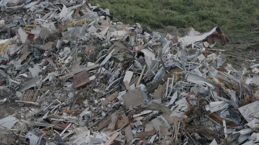 Pile of debris on the side of road after a catastrophic event