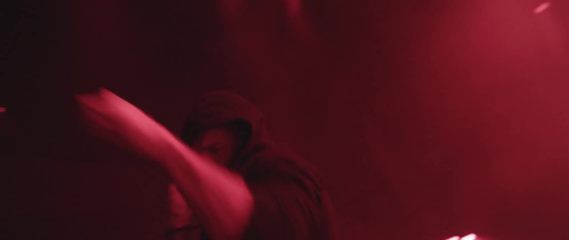A man is shadow boxing in a dark room with lights