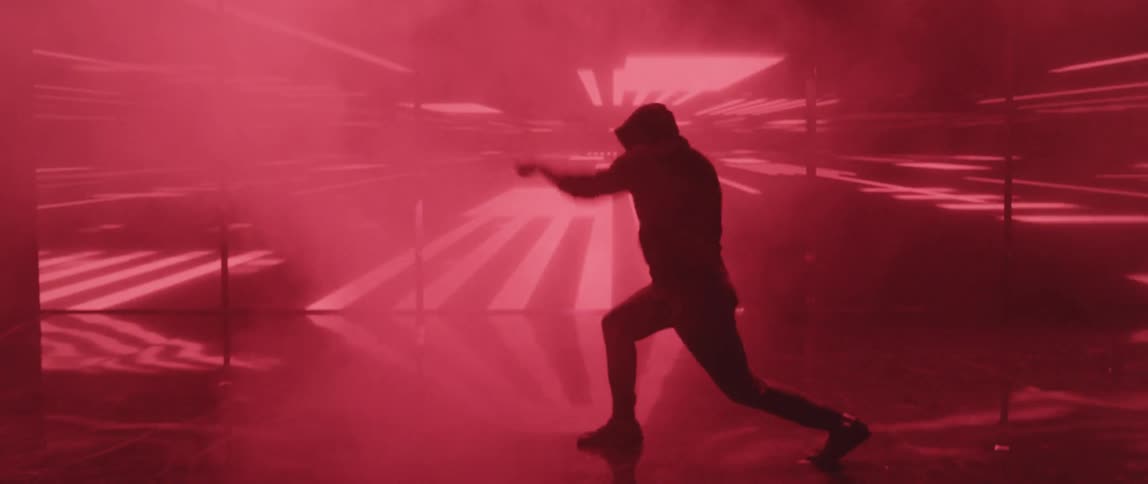A boy shadow boxes in a room with flashing lights