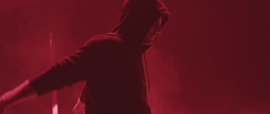 A man stretches in a room with flashing lights